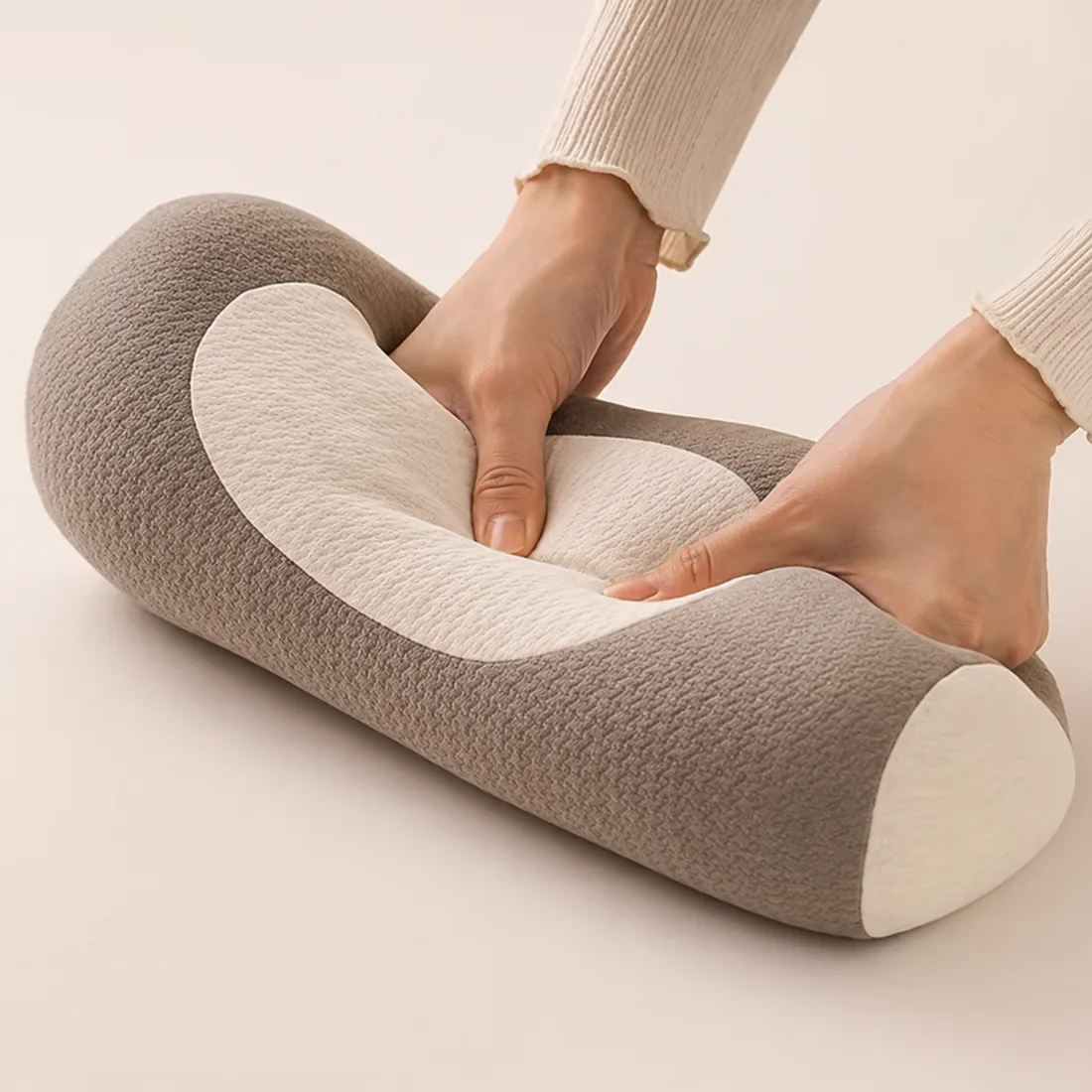 Hands pressing into the HuskRest pillow to show the moldable buckwheat hull and foam fill